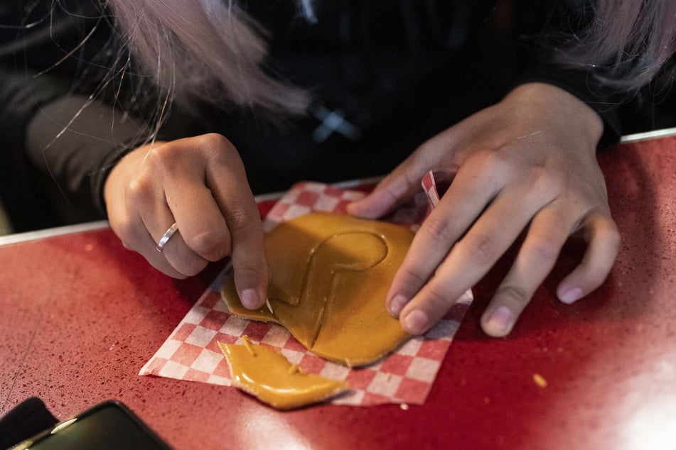 Fans of the show use a toothpick to cut a shape out of a Dalgona candy to complete the honeycomb challenge.