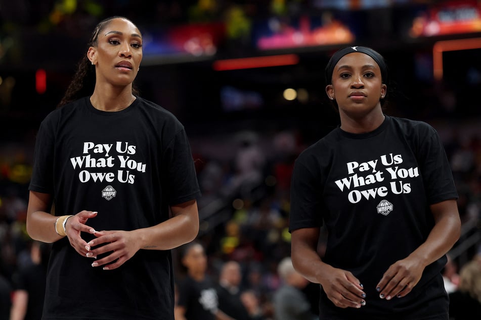 A’ja Wilson and Jackie Young of the Las Vegas Aces wear "Pay Us What You Owe Us" shirts prior to the 2025 AT&T WNBA All-Star Game.
