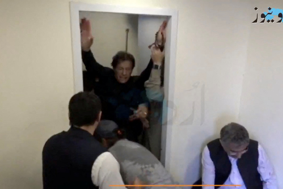 Former Pakistani Prime Minister Imran Khan is shown being helped after he was shot in the shin in Wazirabad, Pakistan, on Thursday.