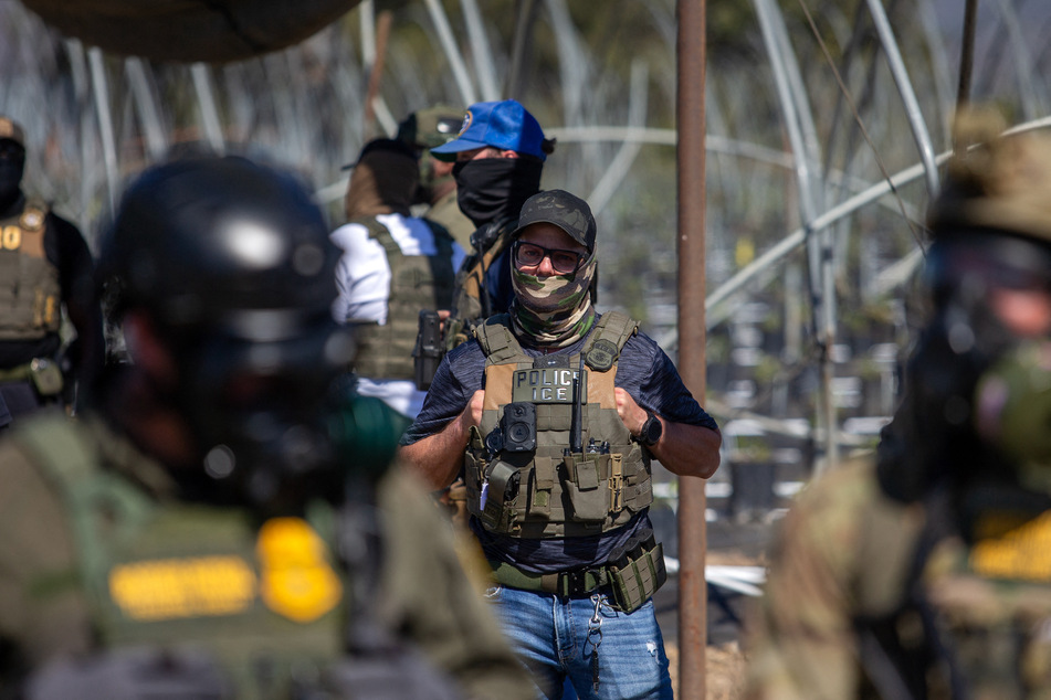 A US Immigration and Customs Enforcement agent watches as Customs and Border Protection officers respond to protesters at Glass House Farms in Camarillo, California, on July 10, 2025.