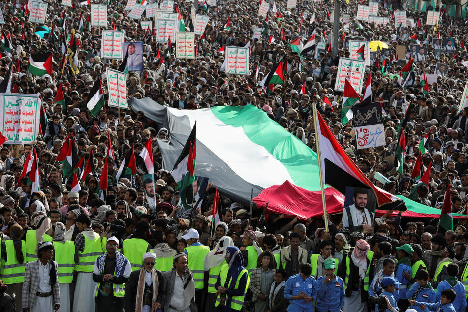 People in Sanaa, Yemen, carry Palestinian flags in solidarity with Gazans under siege during a rally to commemorate 10 Houthi fighters killed by the US Navy in the Red Sea.