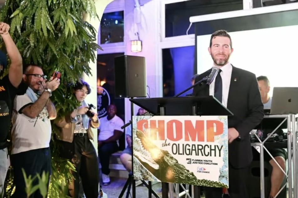 Democratic socialist congressional candidate Oliver Larkin speaks during a "Chomp the Oligarchy" rally on August 14, 2026.