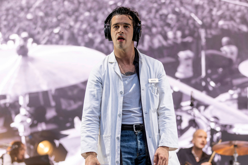 A Malaysian music festival has demanded damages from The 1975 over allegations that frontman Matty Healy caused the event to be canceled.