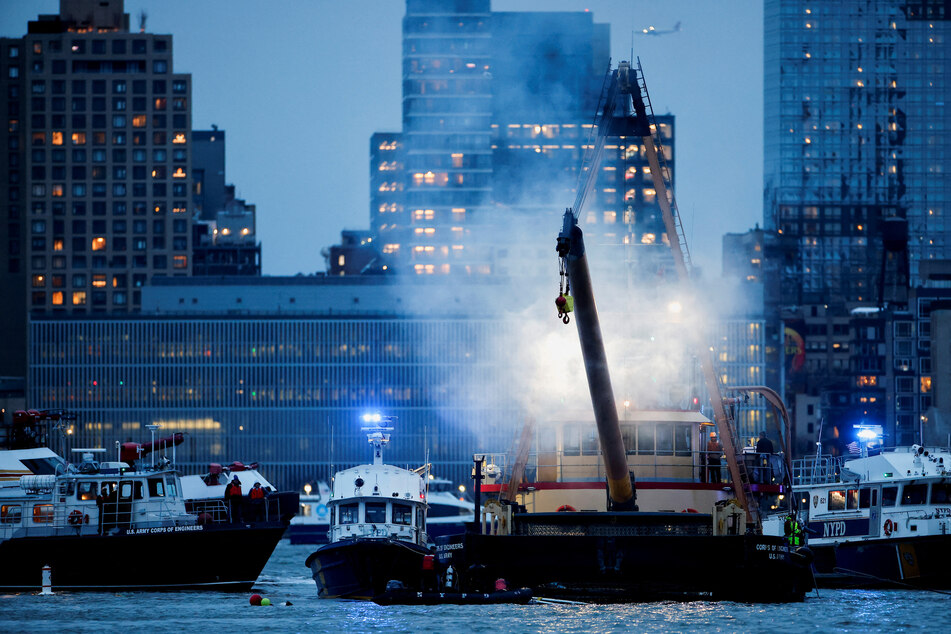 Emergency personnel work at the scene of a helicopter crash on the Hudson River near lower Manhattan in New York, as seen from Newport, New Jersey, on April 10, 2025.