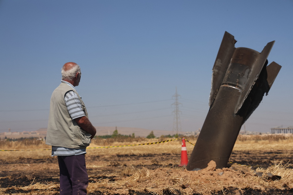 A Syrian farmer looks at an Iranian missile that fell into an agricultural land in the area of Najha, in the countryside of the Syrian capital, after being intercepted by Israeli air defense systems on June 8, 2026.