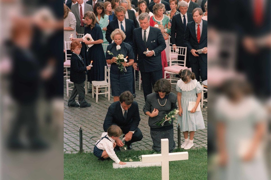 On June 6, 1988 Ethel Kennedy (c.), surrounded by her children and grandchildren, lays flowers on the grave of her husband Senator Robert Kennedy, marking the 20th anniversary of his assassination at a sunset mass at Arlington Cemetery.