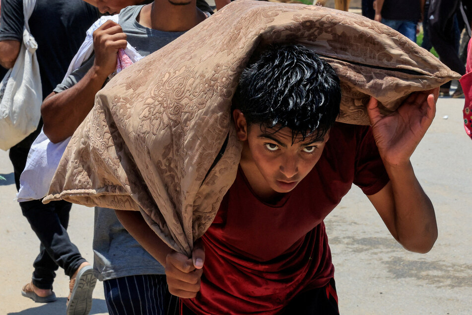 A Palestinian child carries aid supplies from the US-backed Gaza Humanitarian Foundation, in Rafah, in the southern Gaza Strip, on June 9, 2025.