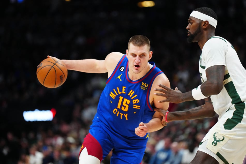 Denver Nuggets center Nikola Jokic drives at Milwaukee Bucks forward Bobby Portis during the second half at Ball Arena.