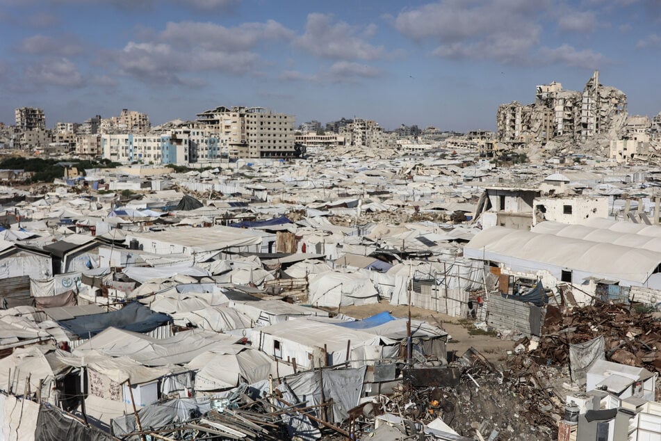 Tents and makeshift shelters housing displaced Palestinians stretch amid the ruins of buildings near the al-Shati refugee camp, west of Gaza City, on July 1, 2026.