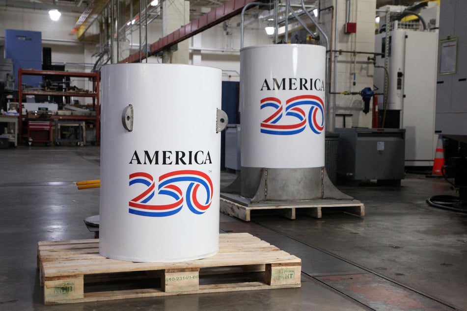 The America250 time capsule (l.) and the bell jar that will fit on top of it are pictured in the machine shop where they were created at the National Institute of Standards and Technology in Gaithersburg, Maryland.