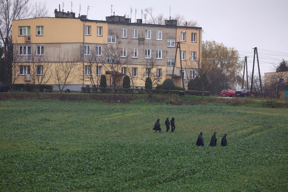 Police officers walk near the site of an explosion in Przewodow, a village in eastern Poland near the border with Ukraine.