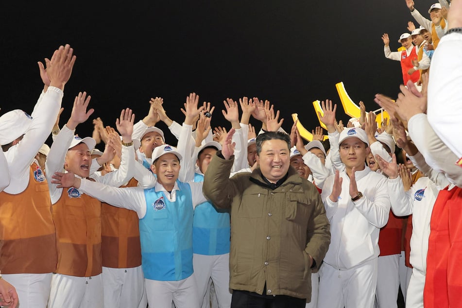 North Korean leader Kim Jong Un (c.) reacted to the launch of North Korea's spy satellite Malligyong-1.