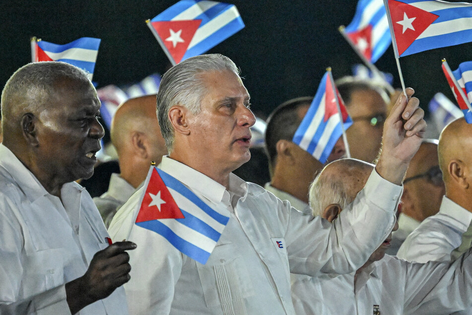 Cuba's President Miguel Díaz-Canel (r.) and head of Parliament Esteban Lazo (l.) wave paper flags during the 73rd anniversary celebration of the guerrilla assault on the Moncada Barracks, led by the late leader Fidel Castro and considered the start of the Cuban Revolution, in Pinar del Rio on July 26, 2026.