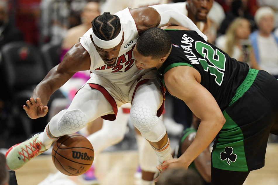Jimmy Butler (l.) tussles for the ball with Celtics forward Grant Williams.