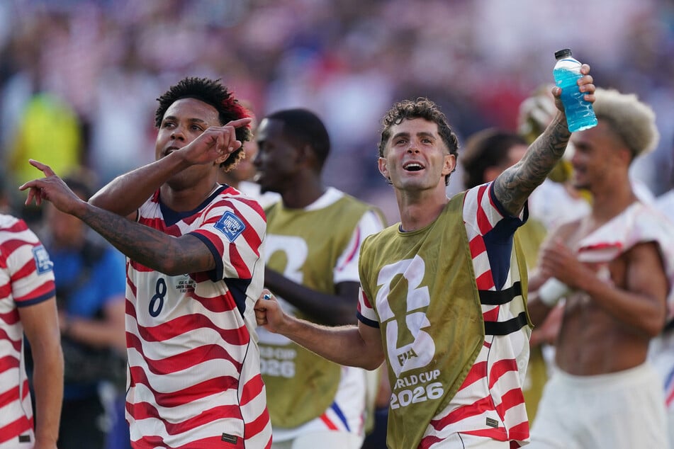 Christian Pulisic (r.) and Weston McKennie (l.) celebrate after the match as Team USA qualify for the round of 16 stage of the World Cup.