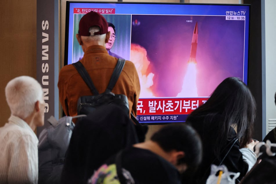 People watch a TV broadcasting a news report on North Korea firing multiple ballistic missiles toward the sea off its east coast, at a railway station in Seoul, South Korea, on October 12, 2026.