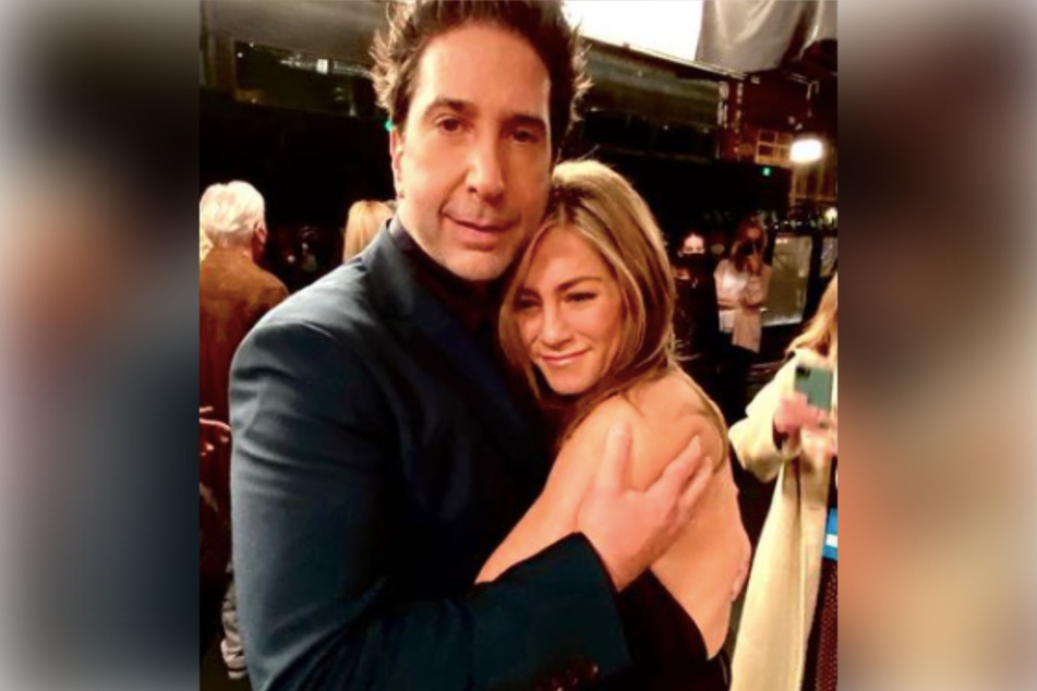 David Schwimmer (l.) hugs Jennifer Aniston (r.) after the conclusion of Friends: The Reunion in a never-before-seen photo.