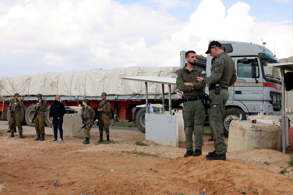 Israeli border police stand guard in front of an Egyptian truck on the sidelines of a demonstration aimed at blocking aid trucks from entering the Palestinian territory on January 29, 2024.