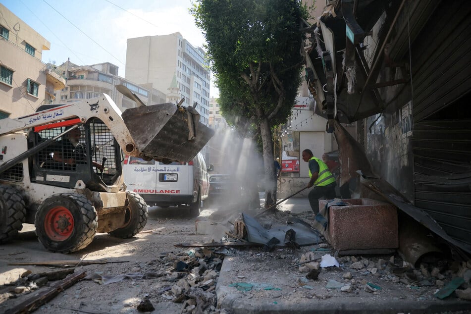 People clear the rubble at the site of an Israeli airstrike that targeted a building in Beirut’s southern suburbs on June 14, 2026.