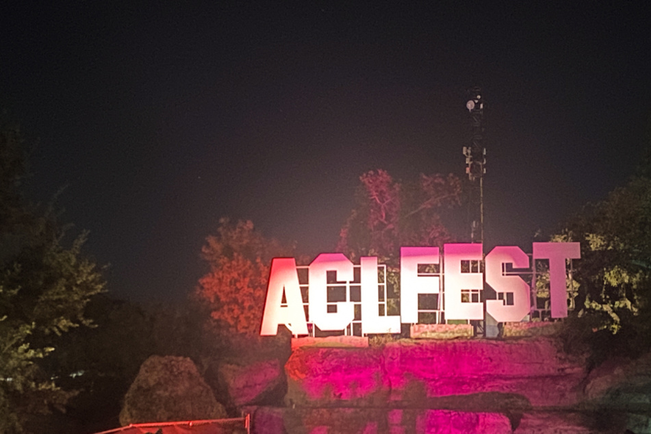 The ACL Fest sign is lit up atop the rocks in the middle of Zilker Park, creating the perfect photo op.