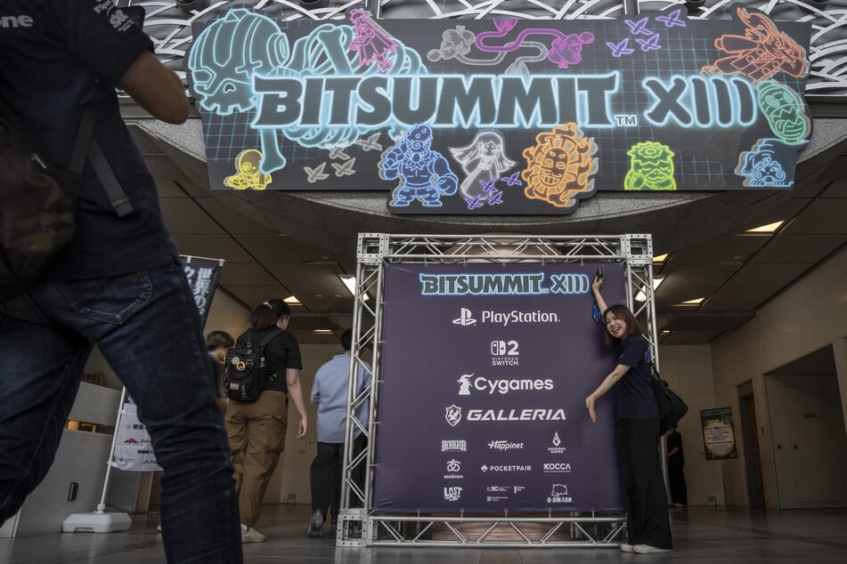 A visitor poses with a signage during the BitSummit indie gaming expo in Kyoto city, Kyoto prefecture on Friday.