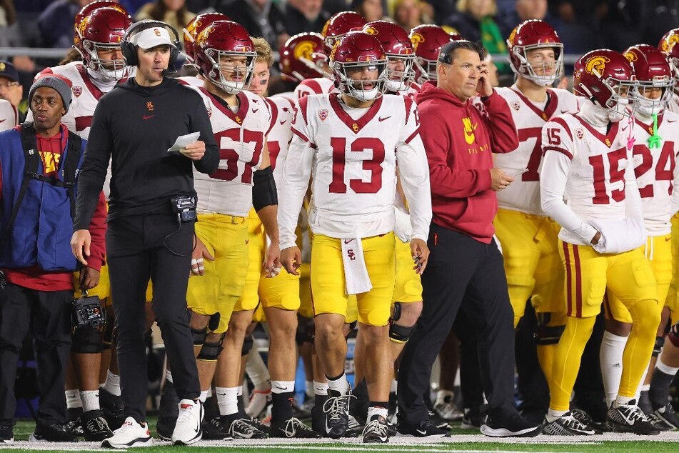 Fans are questioning whether Caleb Williams (c.) is the best college football quarterback.