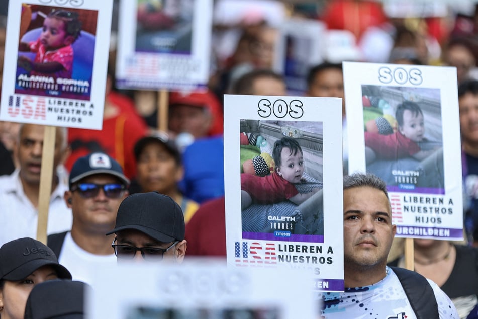 People hold photos of children who remain in the US after being separated from their parents during deportation, in a demonstration in Caracas on July 10, 2025.