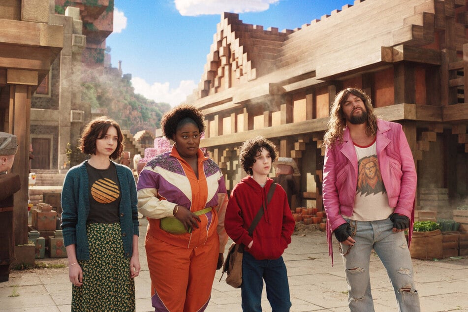 (From l. to r.) Emma Myers, Danielle Brooks, Sebastian Eugene Hansen, and Jason Momoa must find their way back to reality in the gaming flick, A Minecraft Movie.