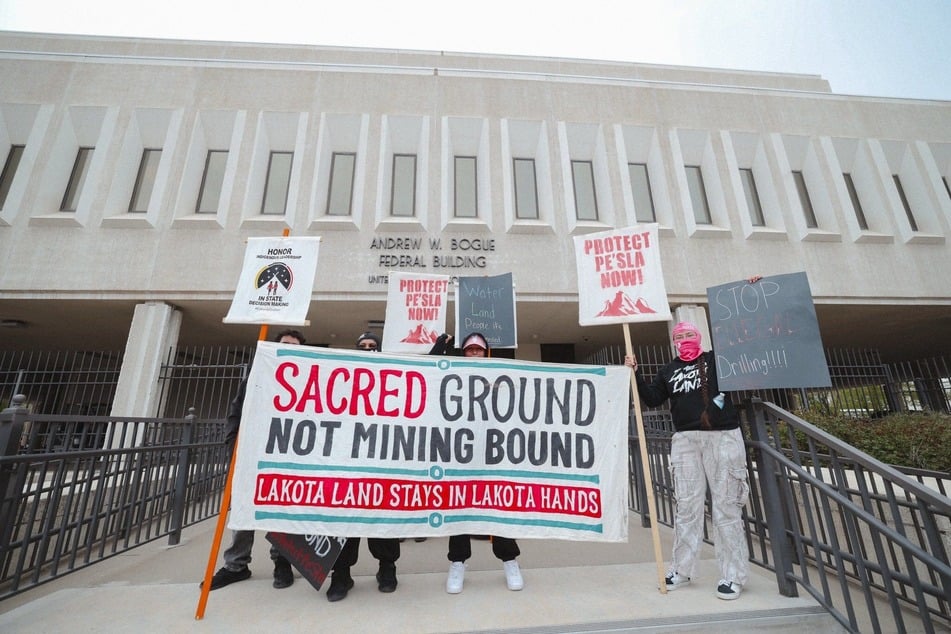 Indigenous demonstrators raise signs outside the Andrew W. Bogue Federal Building and United States Courthouse in Rapid City, South Dakota.
