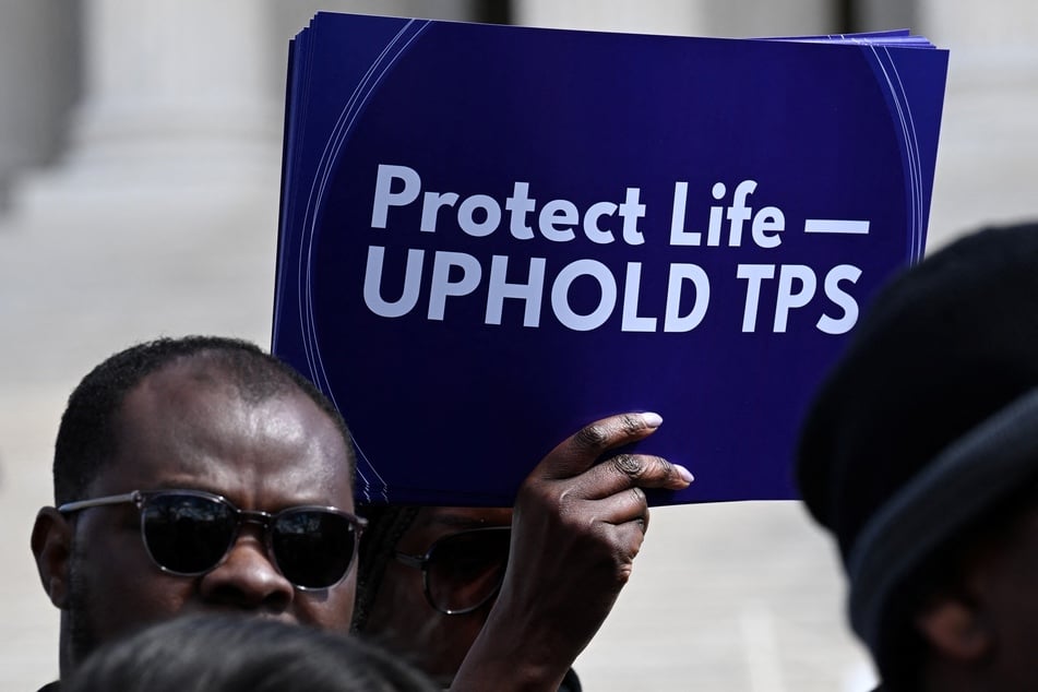 A protestor holds a sign calling on the US Supreme Court to uphold Temporary Protected Status for Haitian refugees on March 16, 2026.