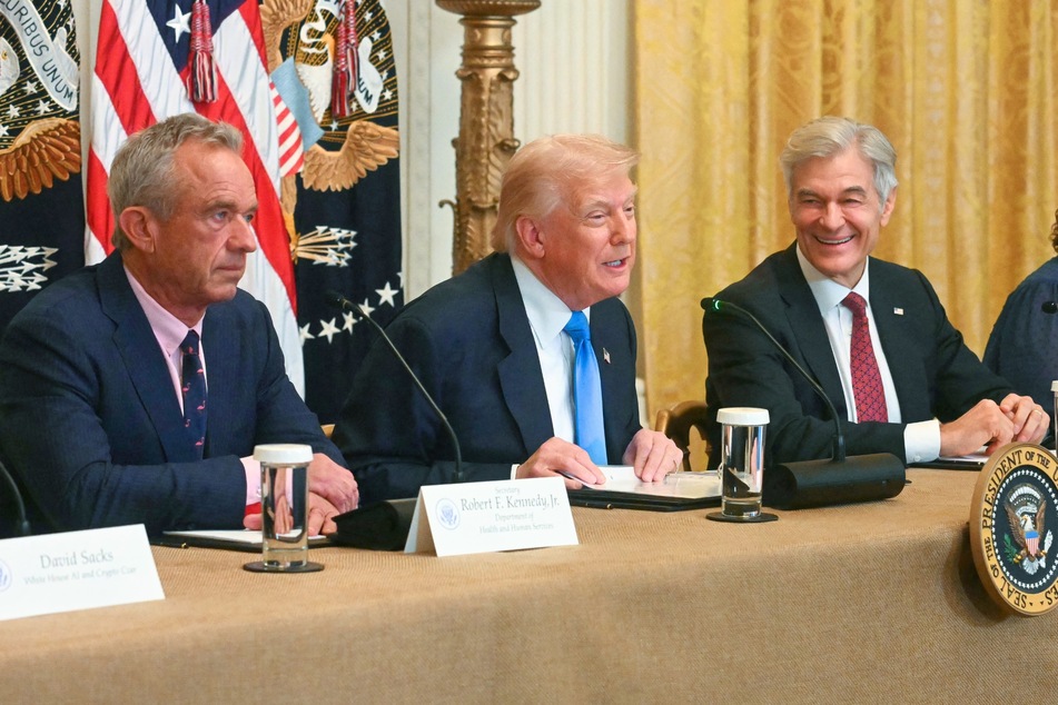 Dr. Mehmet Oz (r.) is facing ridicule after he recently revealed he keeps a giant painting of President Donald Trump (c.) hanging in his office.
