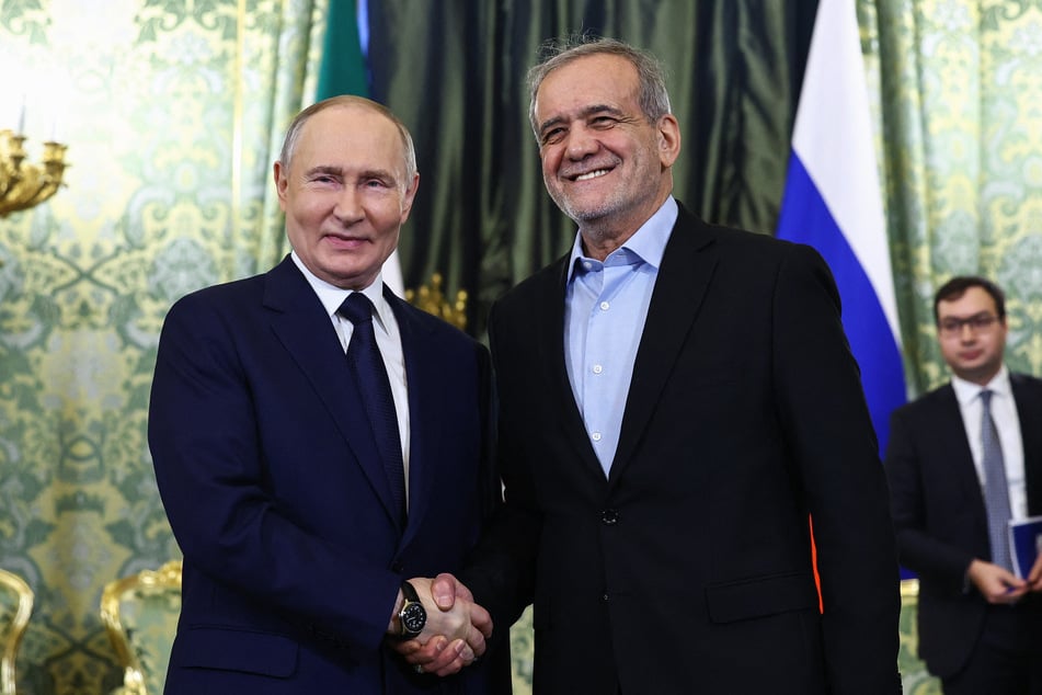 Russian President Vladimir Putin (l.) and Iranian President Masoud Pezeshkian (r.) shake hands during a meeting at the Kremlin in Moscow on January 17, 2025.