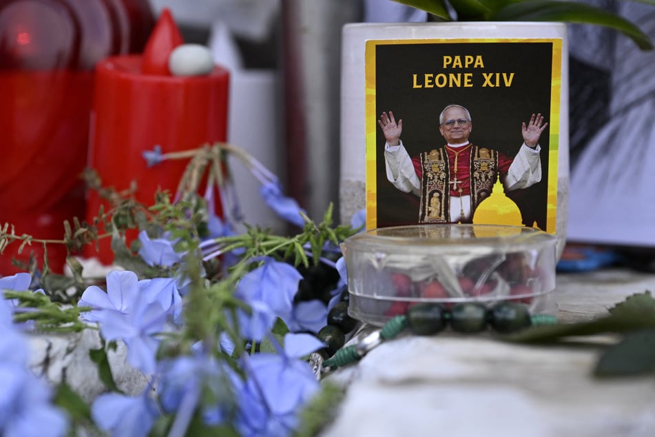 Flowers, candles, and a picture of Pope Leo XIV are laid outside the Gemelli University Hospital, where he underwent surgery to remove a cancerous tumor from his right lung. The Vatican has confirmed that the pontiff has been "deemed fit for discharge."