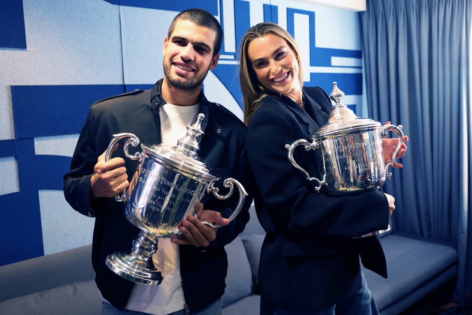 2025 US Open champions Carlos Alcaraz (l.) and Aryna Sabalenka (r.) laugh while making a TikTok during their appearance on the Today Show.