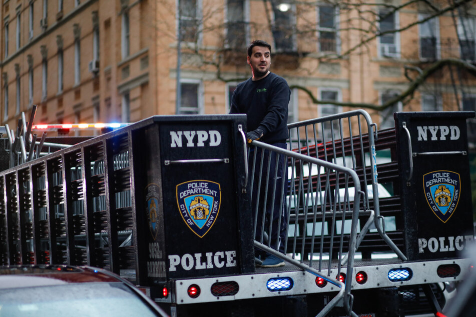 Workers with the NYPD set up barricades outside the offices of the Manhattan District Attorney on Saturday in New York City in anticipation of Donald Trump's arrival.
