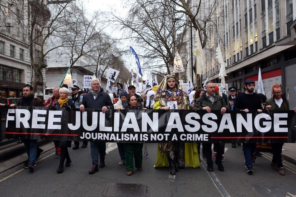Supporters of WikiLeaks founder Julian Assange take part in a Night Carnival for Assange march in London on February 11, 2023.