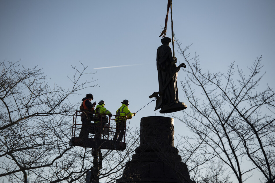 Workers remove the Confederate Memorial statue at Arlington National Cemetery in Virginia on December 20, 2023.