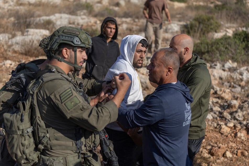 A Palestinian man is arrested by Israeli soldiers during the olive harvest in Israeli-occupied West Bank village of Deir Abu Mashal on October 19. Israel has faced growing criticism over violence during the olive season.