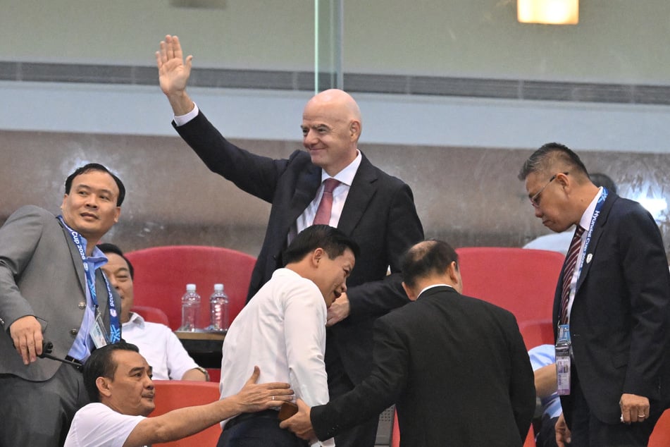 FIFA President Gianni Infantino (c.) waves as he arrives for the second leg of the 2026 ASEAN Championship football final match in Hanoi on August 26, 2026. Infantino said he will still run in the March 2027 FIFA presidential election.