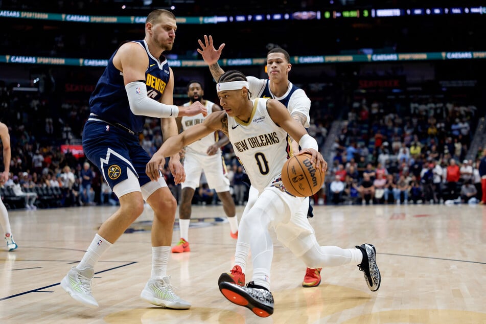 New Orleans Pelicans guard Jeremiah Fears dribbles around Denver Nuggets center Nikola Jokic during the first half at Smoothie King Center.