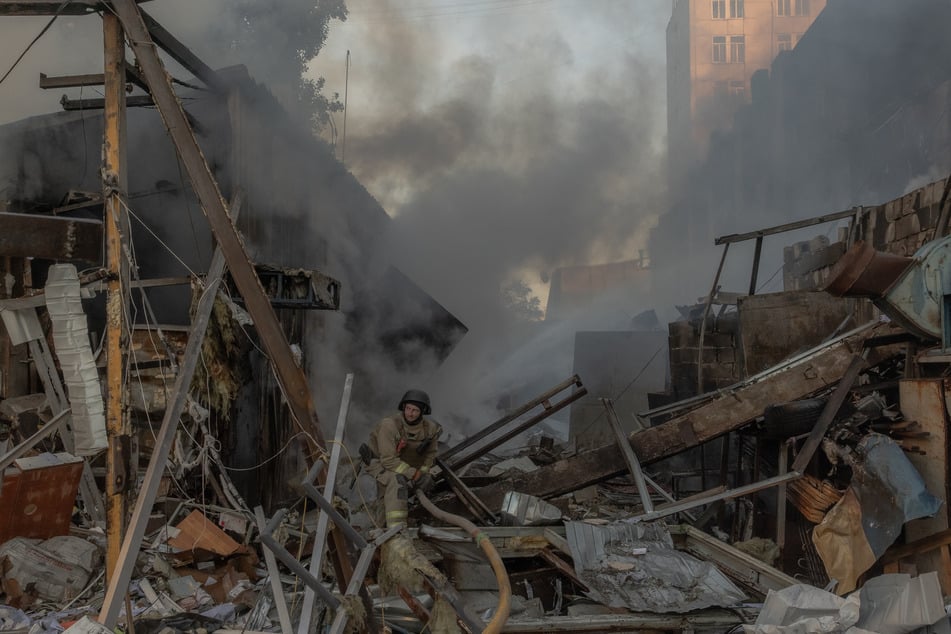 A firefighter works at the site next to a multi-story residential building damaged following massive Russian missile and drone strikes on Kyiv on June 2, 2026.