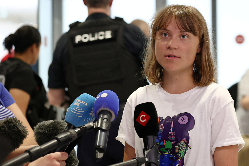 Greta Thunberg talks to journalists surrounded by French police as she arrives at the Paris-Charles de Gaulle Airport after getting deported by Israel on June 10, 2025.