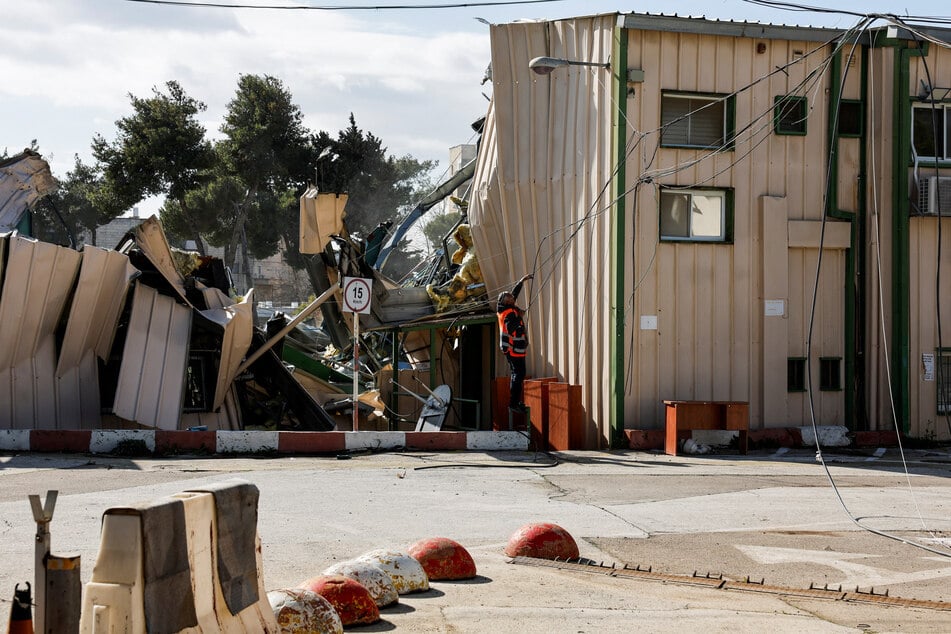 A man handles fallen cables at the East Jerusalem headquarters of UNRWA as it is dismantled by Israeli forces on January 20, 2026.