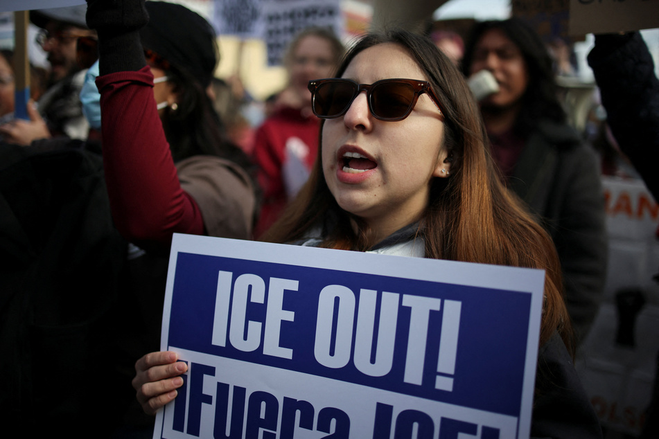 A demonstrator holds a sign as people take part in a protest against ICE raids in Little Village, Chicago, Illinois, on October 24, 2025.