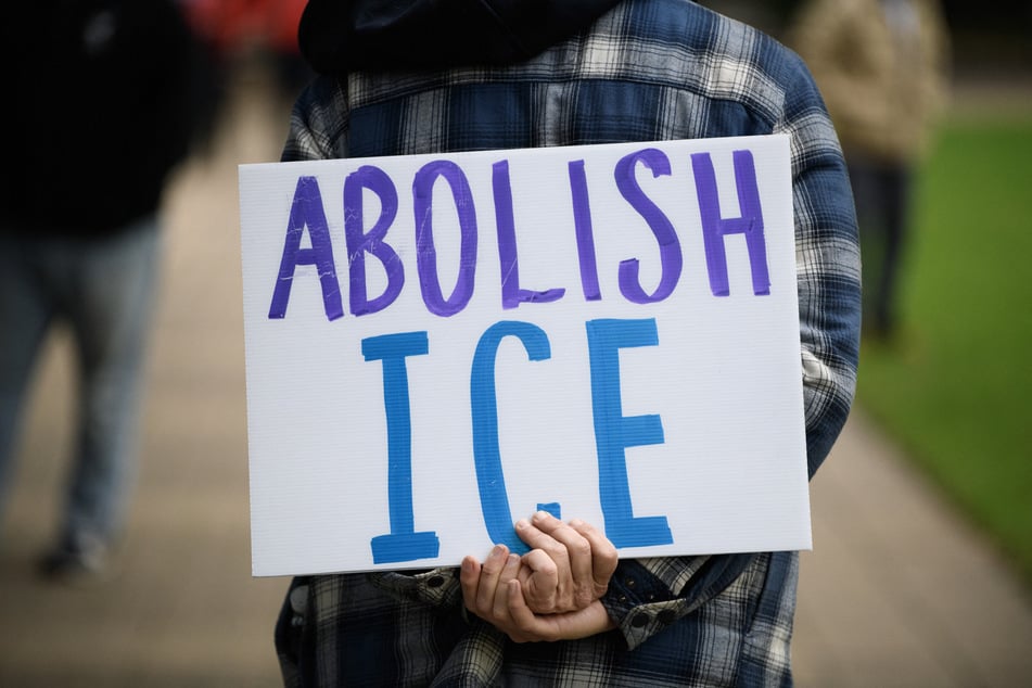A demonstrator holds an "Abolish ICE" sign during a protest in Houston, Texas.