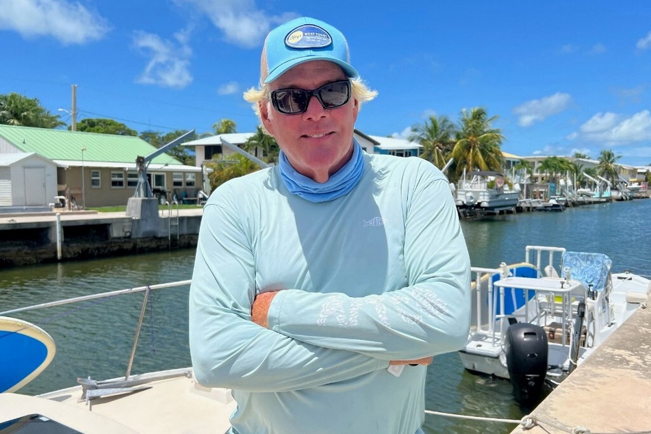 Brian Branigan, a tourist boat captain who has been living and working in the Florida Keys for 15 years operating snorkeling and fishing tours out to the coral reef, stands by one of his chartable boats along the canals of Summerland Key.