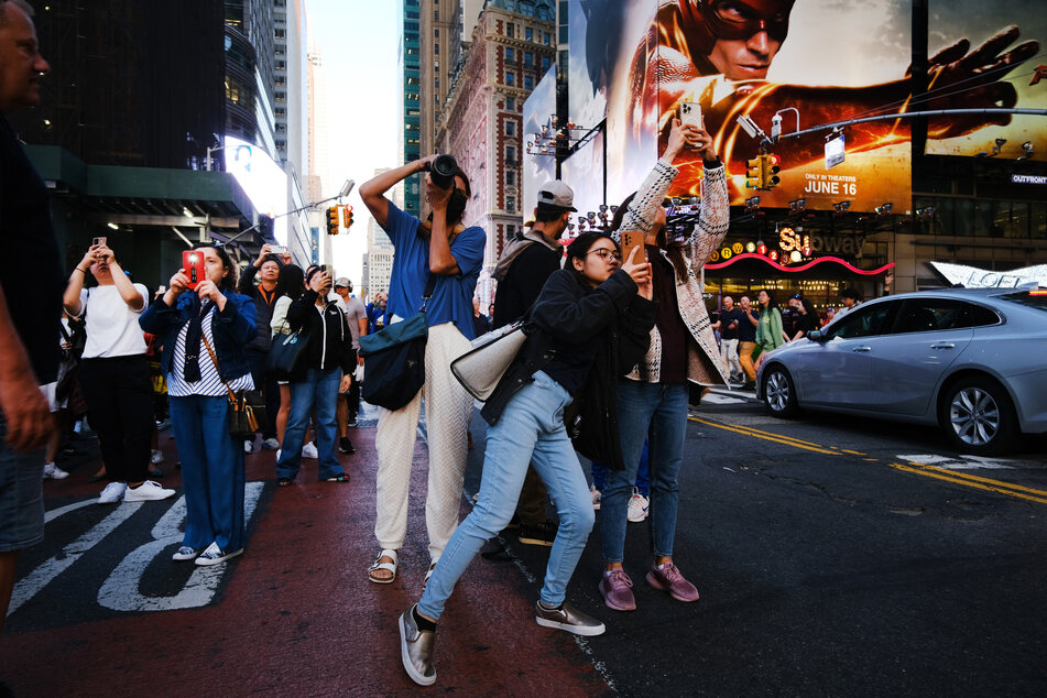 Manhattanhenge event lures photographers with fancy lenses, as well as regular New Yorkers and tourists.