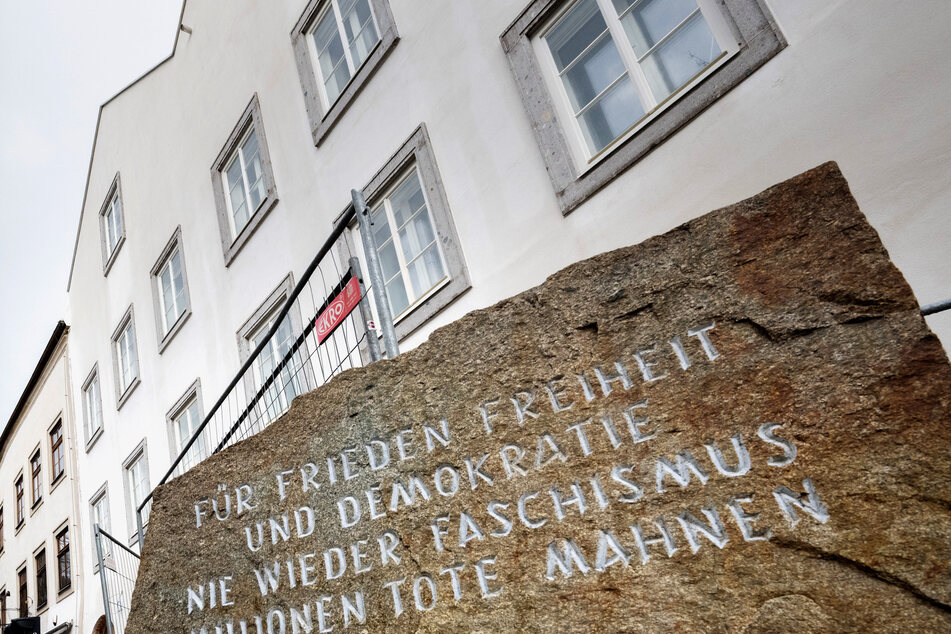 A memorial stone reading "For Peace, Freedom and Democracy - Never Again Fascism - Millions of Dead Warn" stands in front of the birth house of Adolf Hitler in Braunau am Inn, Austria.