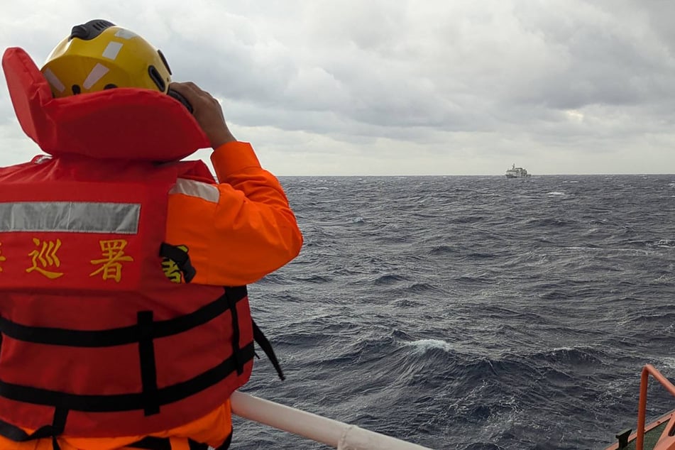 A crewmember on board a Taiwan Coast Guard ship monitors a Chinese coast guard vessel in waters east of Taiwan.