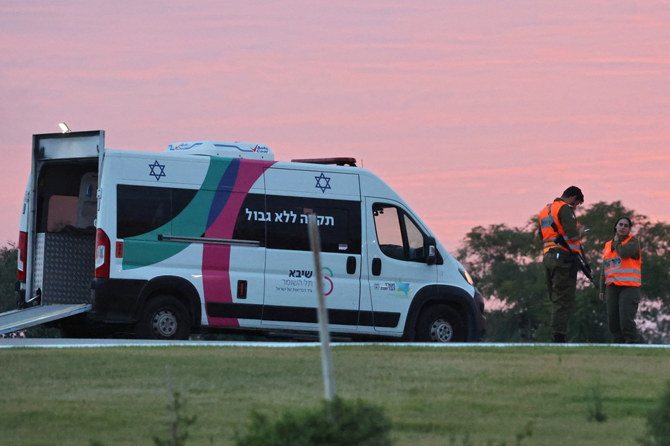 Israeli security forces stand next to an ambulance as medical staff prepare for the arrival of Israeli hostages to be released by Hamas from the Gaza Strip outside Ramat Gan's Sheba medical center in the Tel Aviv district on November 25, 2023.